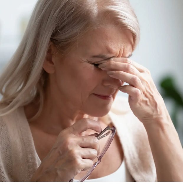 NLP7 hero photo: a stock image of an older woman pinching the bridge of her nose